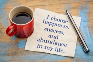 A mug of coffee and a note saying I choose happiness, Success and abundance in my life.