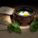 Nettle soup with egg in a traditional Swedish Höganäs pot with seeded bread on the side