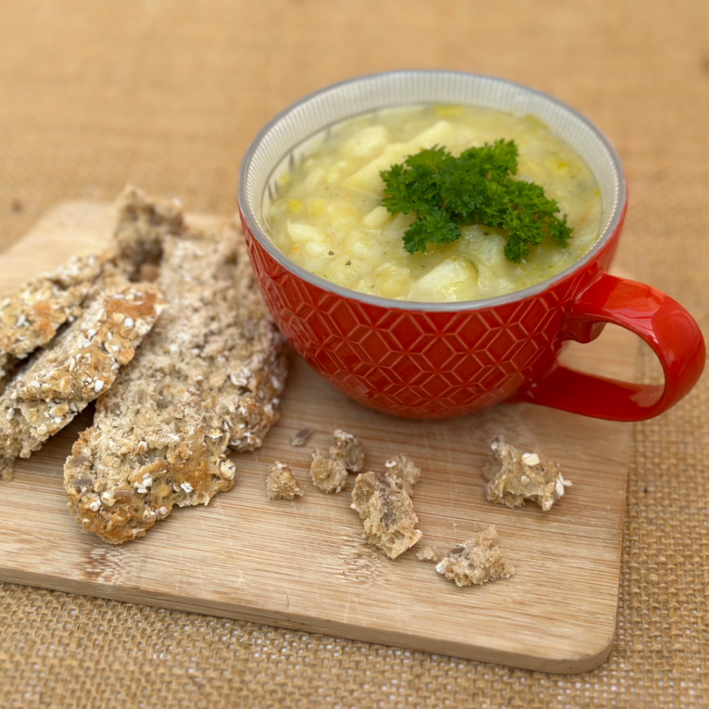 Leek and potato soup served with parsley on top with homemade bread.